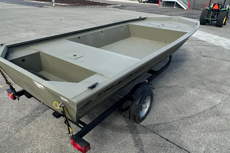 Slide: The Image of 2026 Tracker Grizzly 1648 Utility boat on trailer, parked on concrete surface. - 2