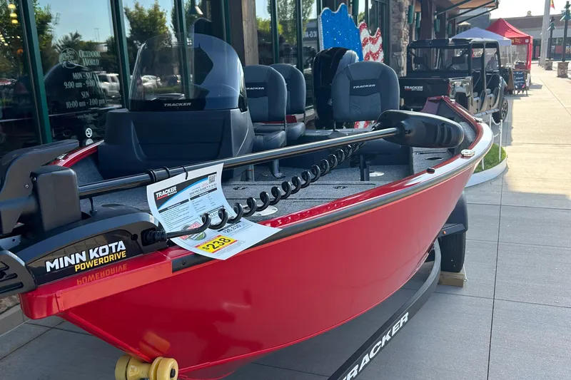 Slide: The Image of 2026 Tracker Pro Guide V-16 SC boat with Minn Kota PowerDrive motor displayed outdoors. - 2