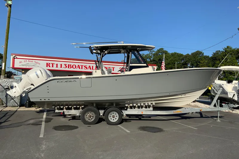 The Image of 2026 Cobia 305 Center Console boat on trailer at dealership. - 0