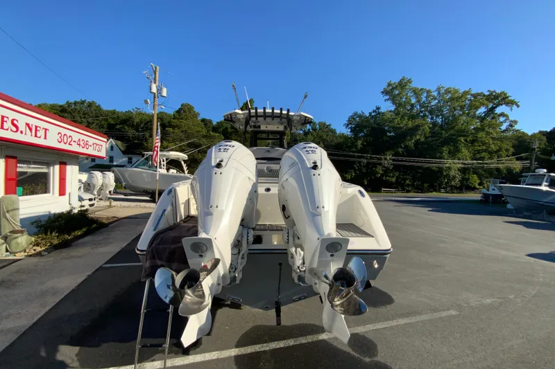 Slide: The Image of 2026 Cobia 305 Center Console boat with dual outboard engines in a parking lot. - 10