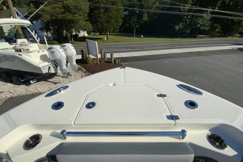 Slide: The Image of 2026 Cobia 305 Center Console boat with triple Yamaha engines, parked on a sunny day. - 102