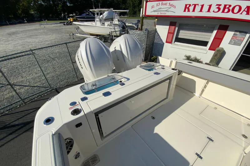 Slide: The Image of 2026 Cobia 305 Center Console boat with dual Yamaha engines at a boat dealership. - 104