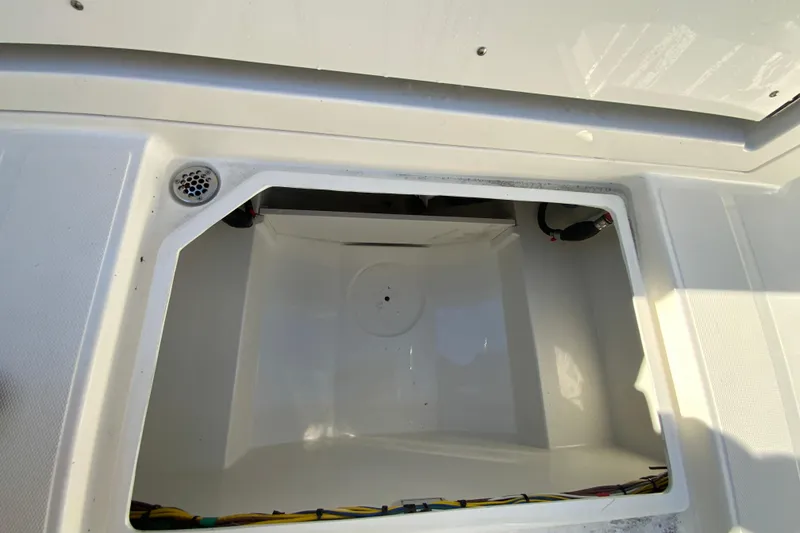 Slide: The Image of 2026 Cobia 305 Center Console storage compartment with drainage and wiring. - 107