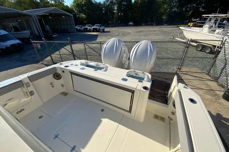 Slide: The Image of 2026 Cobia 305 Center Console boat with dual outboard engines in a marina setting. - 16