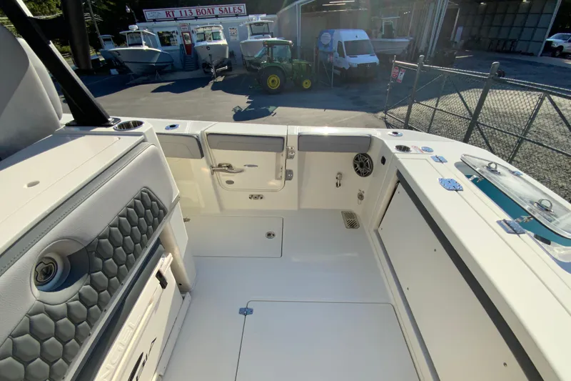 Slide: The Image of 2026 Cobia 305 Center Console boat interior at dealership, showcasing seating and storage. - 23