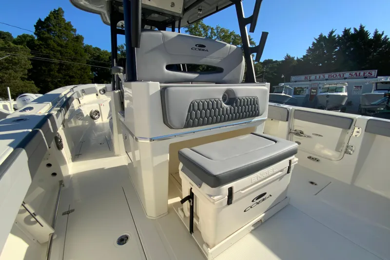 Slide: The Image of 2026 Cobia 305 Center Console boat interior with seating and storage, displayed at a boat sales lot. - 32