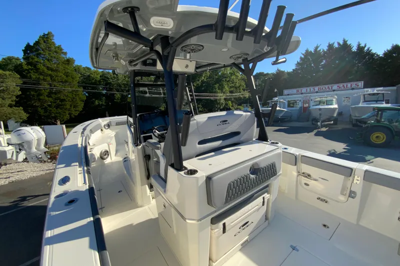 Slide: The Image of 2026 Cobia 305 Center Console boat at dealership, showcasing sleek design and spacious deck. - 33
