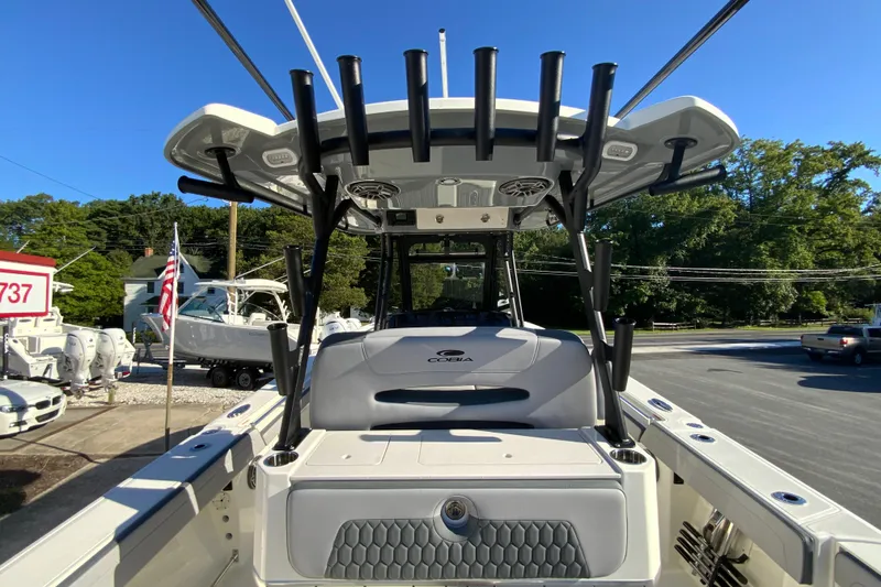 Slide: The Image of 2026 Cobia 305 Center Console boat with rod holders and seating, displayed outdoors. - 35