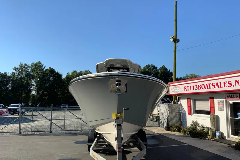 Slide: The Image of 2026 Cobia 305 Center Console boat displayed at dealership under clear blue sky. - 4
