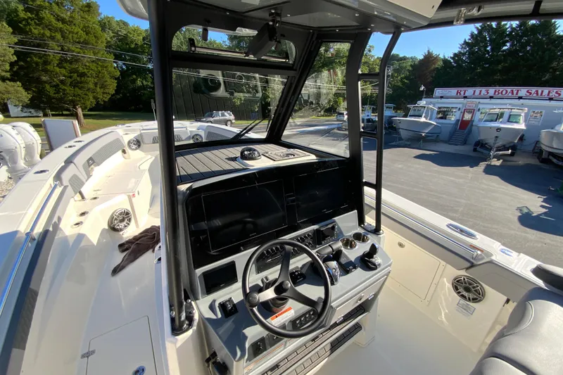 Slide: The Image of 2026 Cobia 305 Center Console boat interior with modern helm and controls at a dealership. - 41