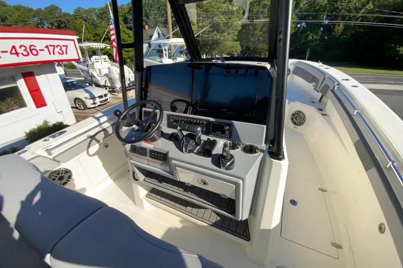 Slide: The Image of 2026 Cobia 305 Center Console boat dashboard with steering wheel and controls. - 42