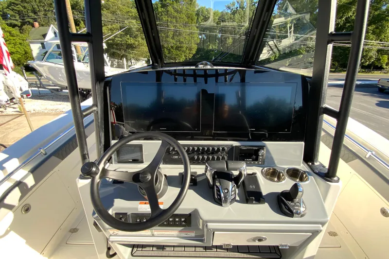 Slide: The Image of 2026 Cobia 305 Center Console boat dashboard with steering wheel and electronic controls. - 43