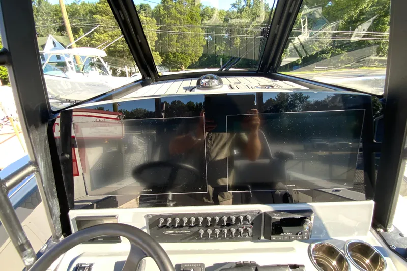 Slide: The Image of 2026 Cobia 305 Center Console dashboard with dual Garmin displays and control panel. - 44