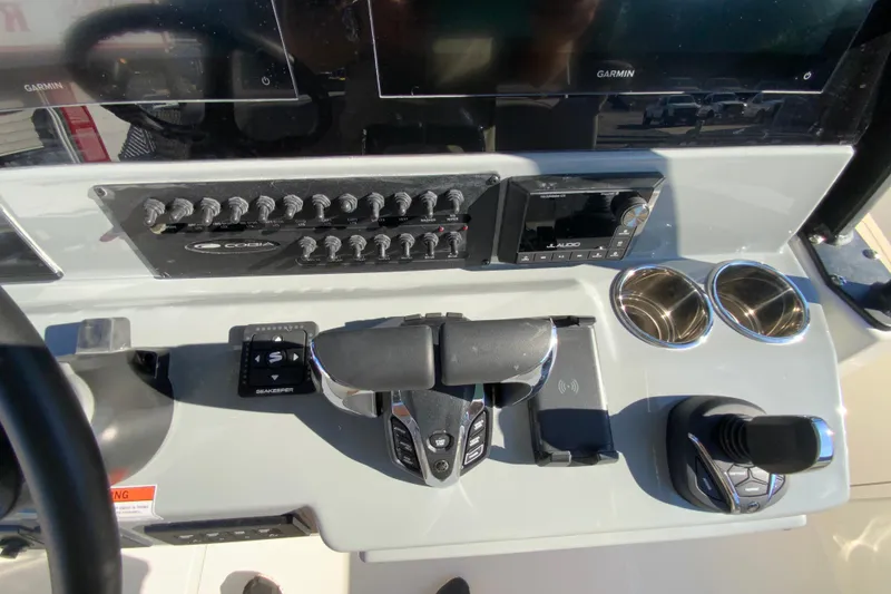 Slide: The Image of 2026 Cobia 305 Center Console dashboard with controls, switches, and cup holders. - 45
