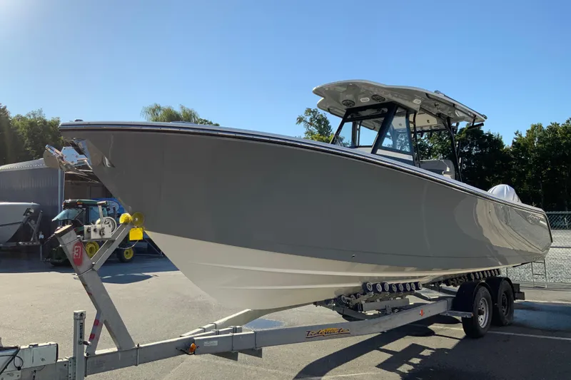 Slide: The Image of 2026 Cobia 305 Center Console boat on trailer under clear blue sky. - 5