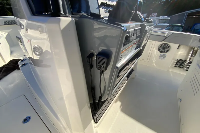 Slide: The Image of 2026 Cobia 305 Center Console boat interior with control panel and speaker. - 51