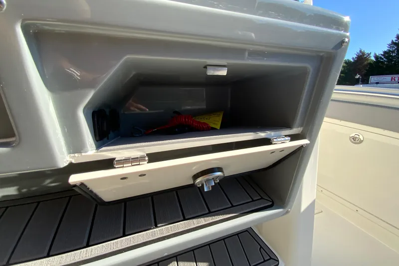 Slide: The Image of Open storage compartment on 2026 Cobia 305 Center Console boat, showing interior details. - 53