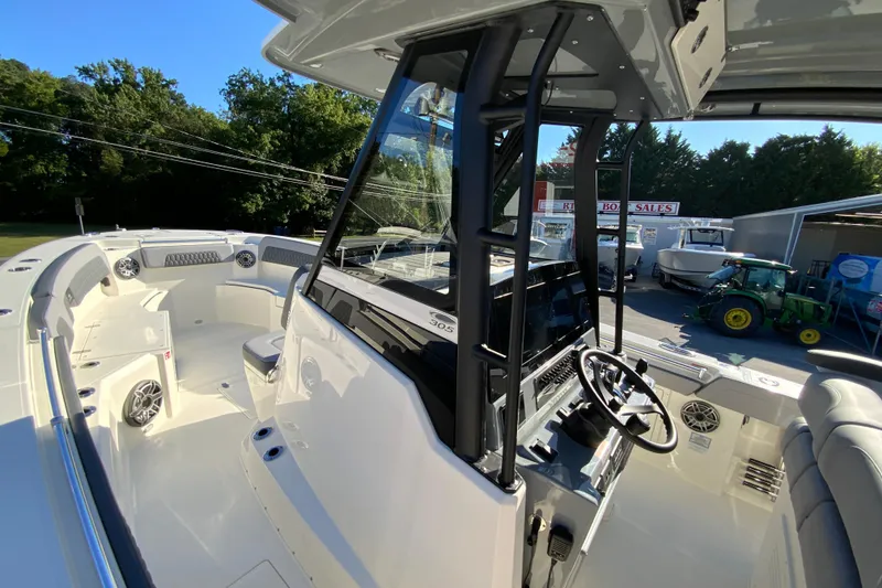Slide: The Image of 2026 Cobia 305 Center Console boat interior with steering wheel and seating area. - 60