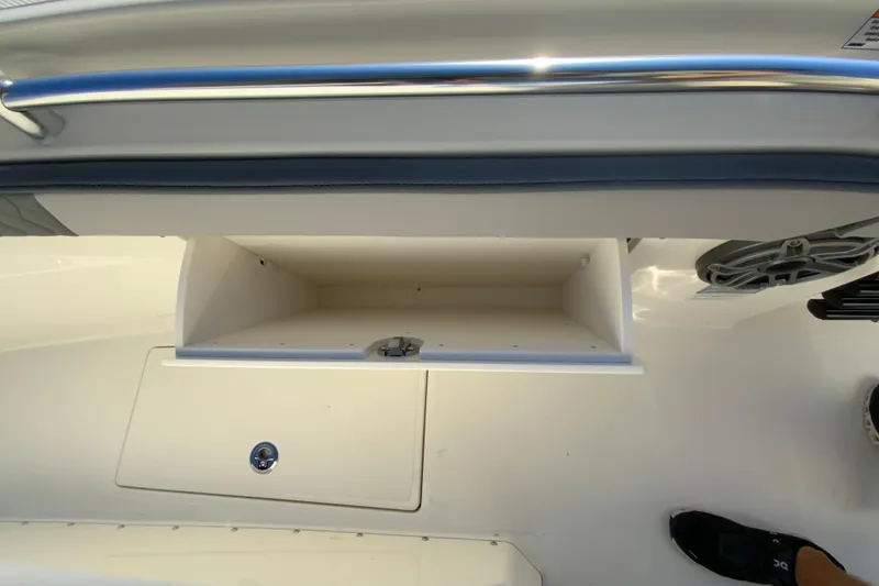 Slide: The Image of 2026 Cobia 305 Center Console boat storage compartment with sleek design and stainless steel railing. - 63