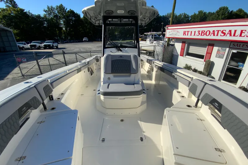 Slide: The Image of 2026 Cobia 305 Center Console boat at dealership, showcasing spacious deck and seating. - 67