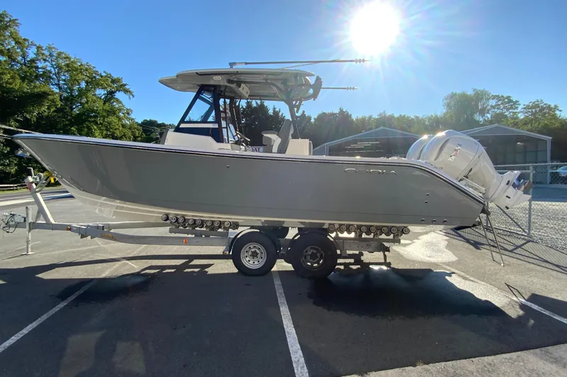 Slide: The Image of 2026 Cobia 305 Center Console boat on trailer under bright sunlight. - 7