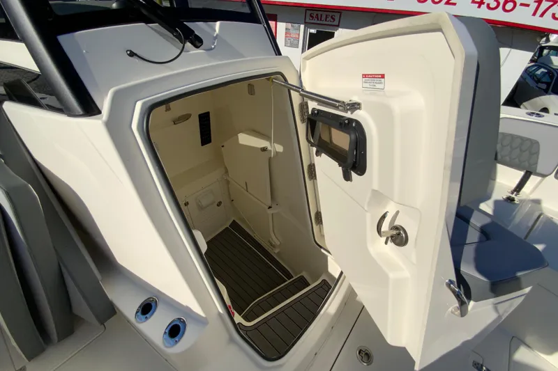 Slide: The Image of 2026 Cobia 305 Center Console boat interior cabin with open door view. - 78
