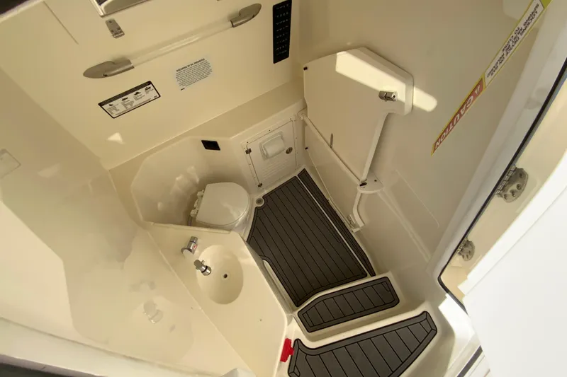 Slide: The Image of 2026 Cobia 305 Center Console boat interior with compact bathroom amenities. - 79