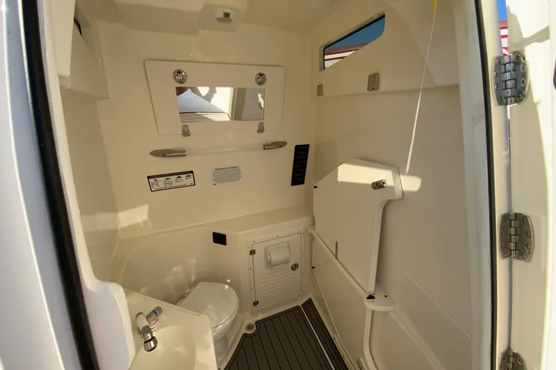 Slide: The Image of 2026 Cobia 305 Center Console boat interior with compact bathroom amenities. - 80