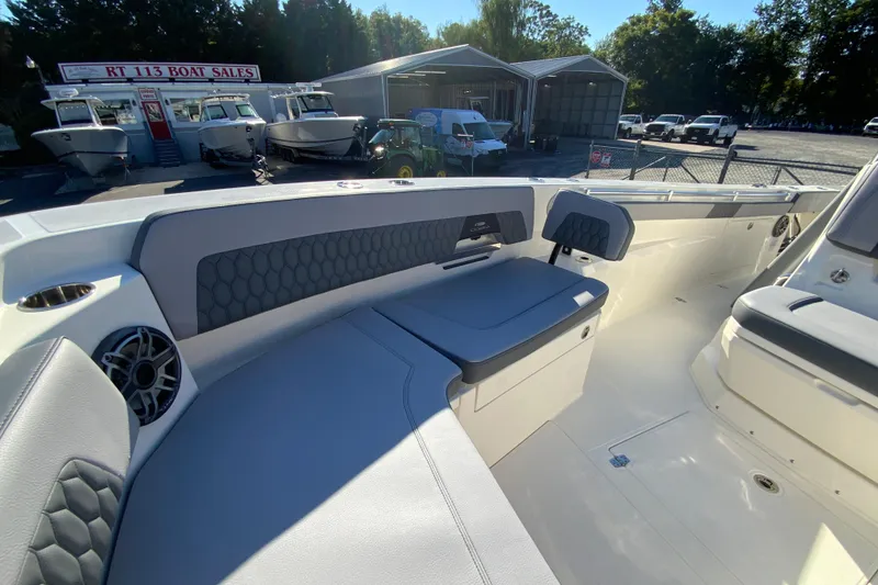Slide: The Image of 2026 Cobia 305 Center Console boat interior with seating and speaker, at a boat sales lot. - 93