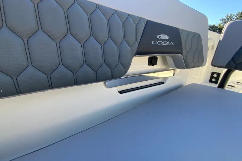 Slide: The Image of 2026 Cobia 305 Center Console boat interior with cushioned seating and logo detail. - 96