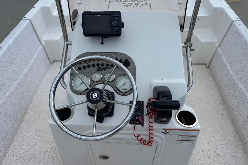 Slide: The Image of 2019 Carolina Skiff 218 DLV boat console with steering wheel and navigation equipment. - 13