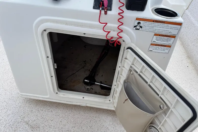Slide: The Image of Open storage compartment on a 2019 Carolina Skiff 218 DLV boat with warning labels. - 15