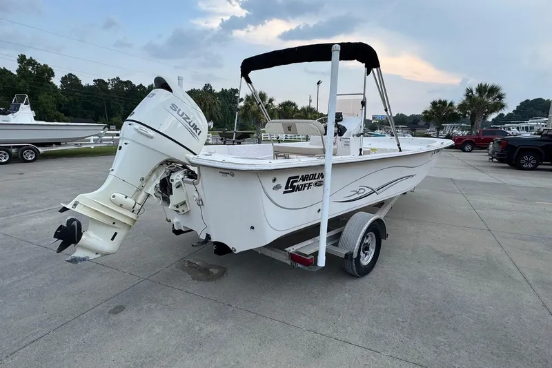 Slide: The Image of 2019 Carolina Skiff 218 DLV boat with Suzuki outboard motor on trailer. - 2