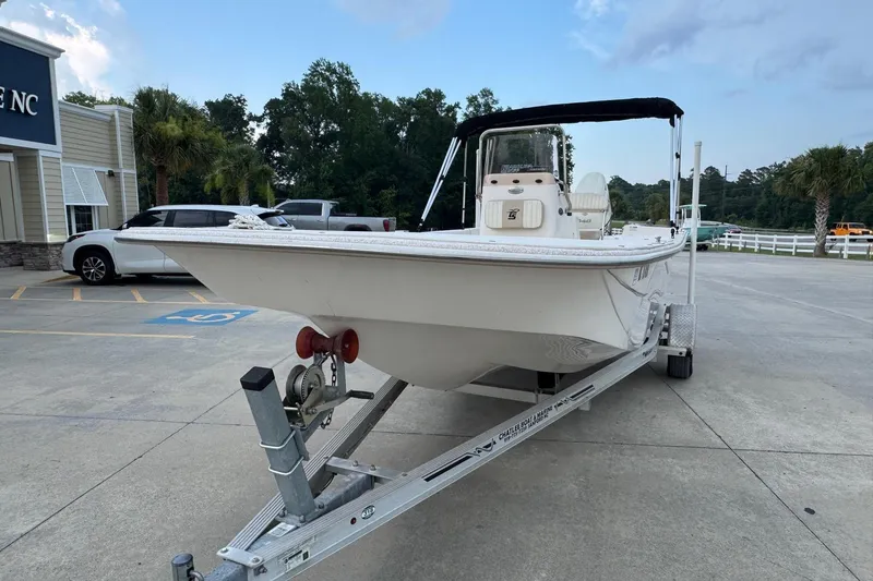 Slide: The Image of 2019 Carolina Skiff 218 DLV boat on trailer in parking lot, under cloudy sky. - 5