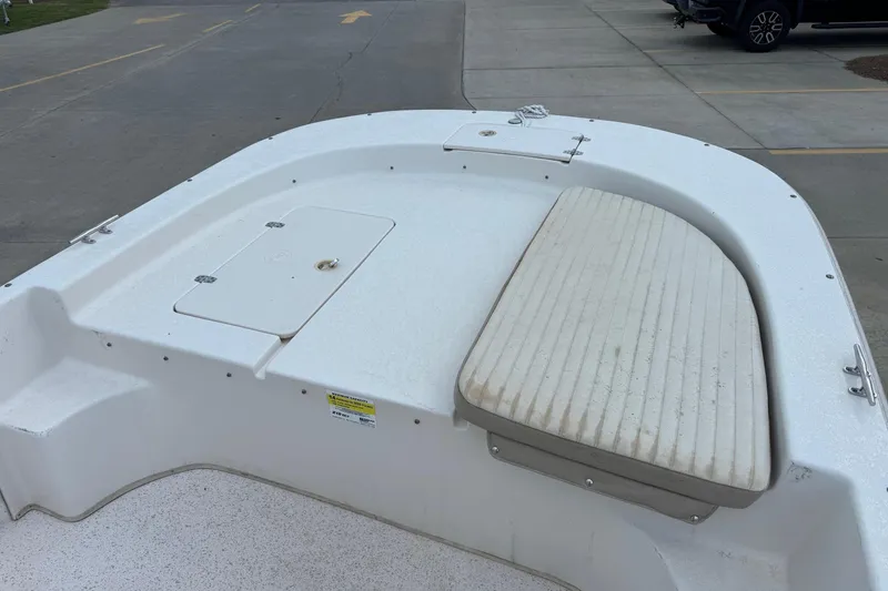 Slide: The Image of 2019 Carolina Skiff 218 DLV boat deck with storage hatch and cushioned seating. - 6