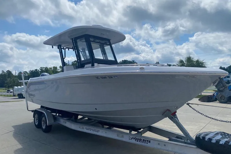 The Image of 2021 Robalo R272 Center Console boat on trailer under cloudy sky. - 0