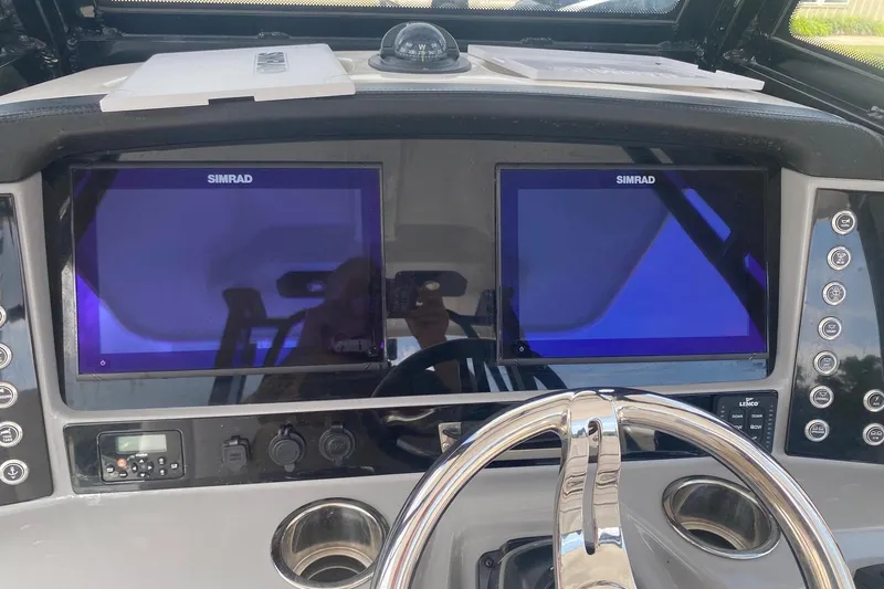 Slide: The Image of 2021 Robalo R272 Center Console dashboard with dual Simrad displays and steering wheel. - 15