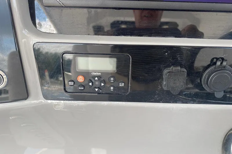 Slide: The Image of 2021 Robalo R272 Center Console dashboard with Clarion audio system and input ports. - 17