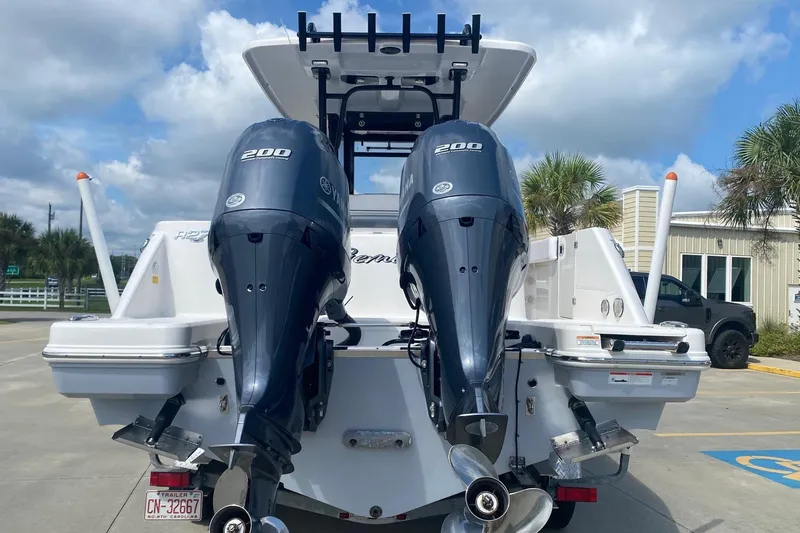 Slide: The Image of 2021 Robalo R272 Center Console boat with dual Yamaha 200 engines, parked outdoors. - 2