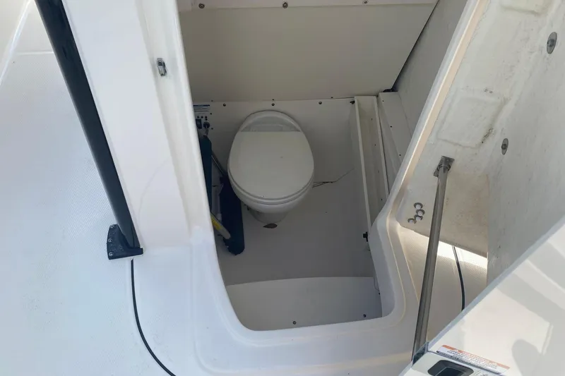 Slide: The Image of 2021 Robalo R272 Center Console boat interior with compact marine toilet. - 5