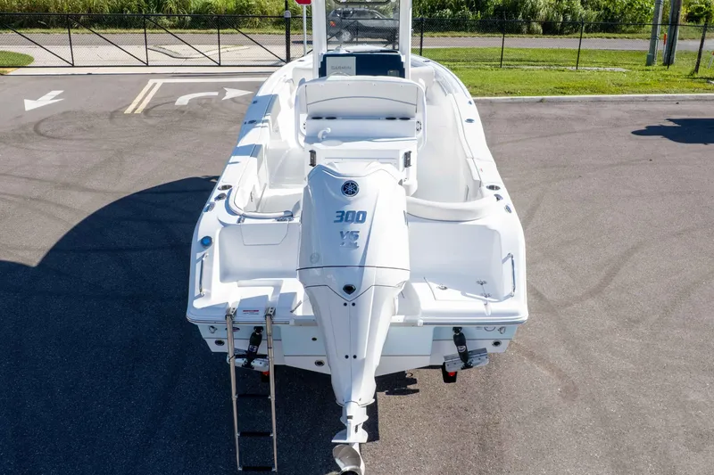 Slide: The Image of 2025 Sea Hunt Ultra 245 SE boat with powerful 300 HP engine, parked on pavement. - 10