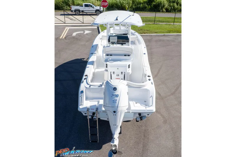 Slide: The Image of 2025 Sea Hunt Ultra 245 SE boat, rear view, parked on pavement. - 11