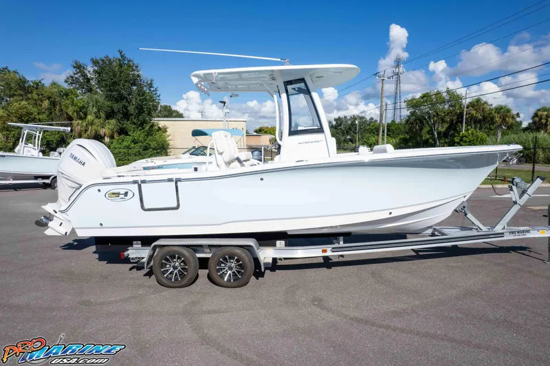 Slide: The Image of 2025 Sea Hunt Ultra 245 SE boat on trailer, parked outdoors under clear blue sky. - 15