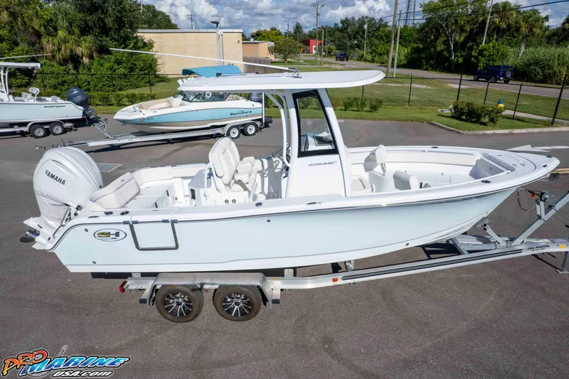 Slide: The Image of 2025 Sea Hunt Ultra 245 SE boat on trailer, featuring Yamaha engine, parked outdoors. - 16