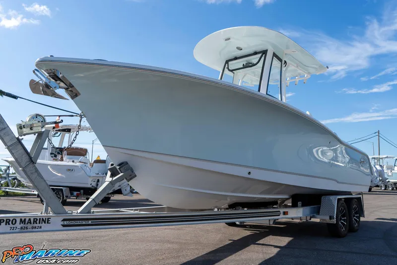 Slide: The Image of 2025 Sea Hunt Ultra 245 SE boat on trailer under clear blue sky. - 17