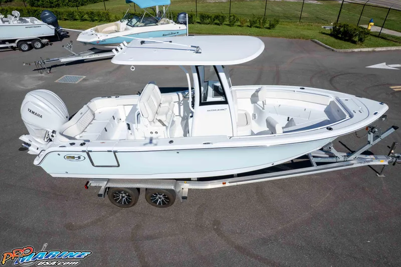 Slide: The Image of 2025 Sea Hunt Ultra 245 SE boat on trailer, featuring Yamaha engine, parked outdoors. - 18