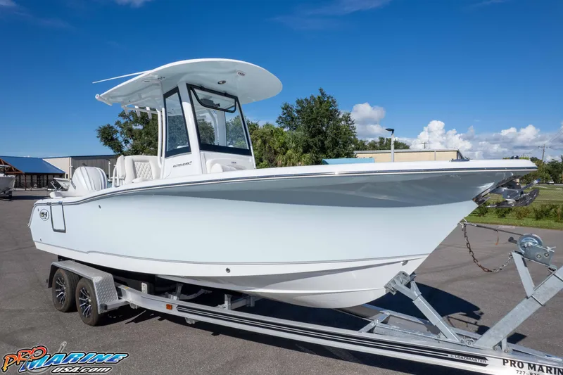 Slide: The Image of 2025 Sea Hunt Ultra 245 SE boat on trailer under clear blue sky. - 19