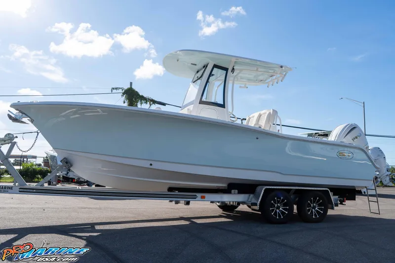 Slide: The Image of 2025 Sea Hunt Ultra 245 SE boat on trailer under clear blue sky. - 20