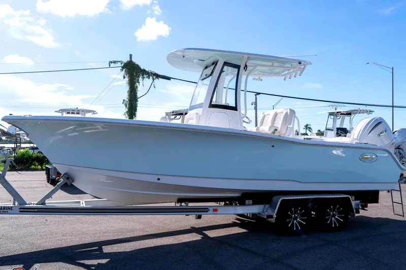 Slide: The Image of 2025 Sea Hunt Ultra 245 SE boat on trailer, sunny day, clear sky. - 22