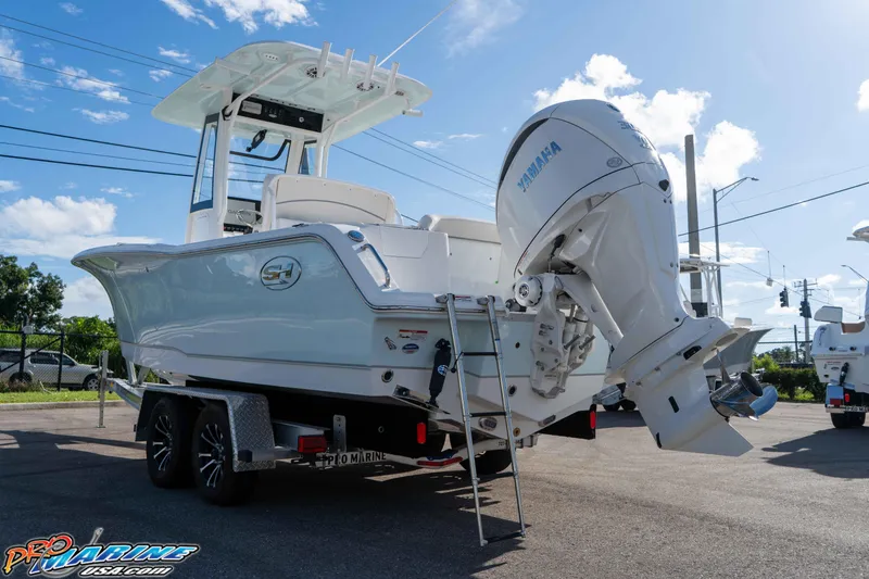 Slide: The Image of 2025 Sea Hunt Ultra 245 SE boat with Yamaha engine on trailer, sunny day. - 24